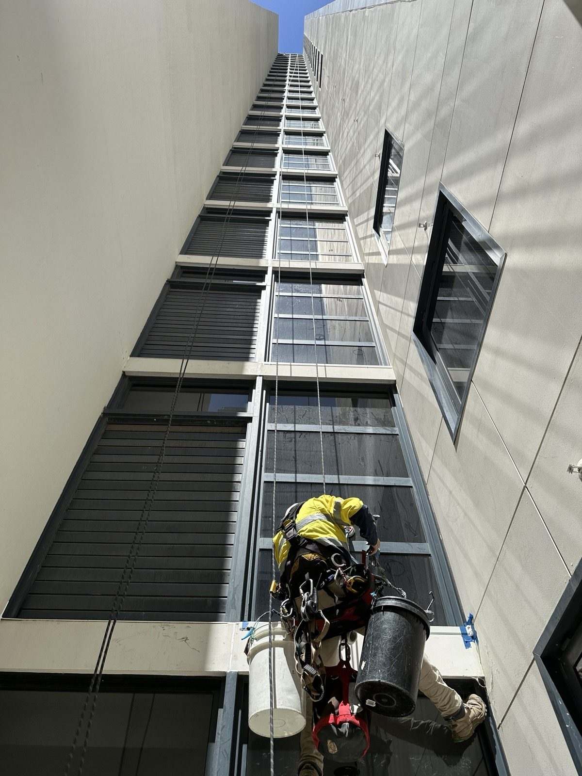 Mission Possible rope access technician inspecting a high-rise building facade in Perth