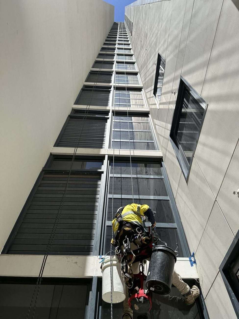 Mission Possible rope access technician inspecting a high-rise building facade in Perth